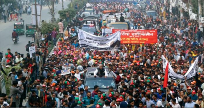 Bangladesh's Home Minister and leader of ruling Awami League party Asaduzzaman Khan (C) greets his supporters during a campaign rally ahead of the general elections in Dhaka.